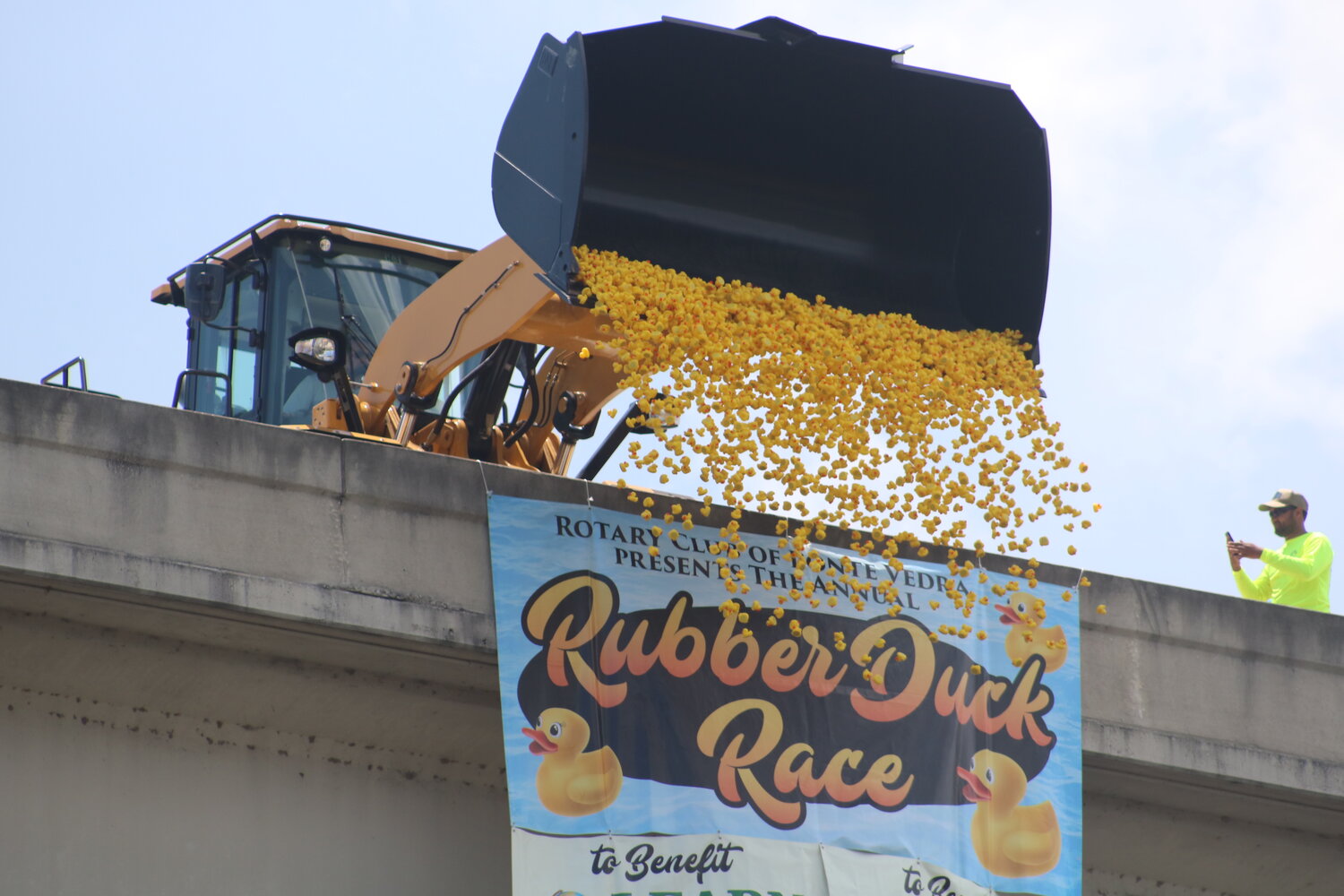 A front loader dumps 3,000 rubber ducks from Palm Valley Bridge during the annual Rotary Club of Ponte Vedra Rubber Duck Race.